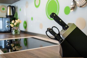 A kitchen counter with a knife block, a coffee maker, and a vase with flowers.