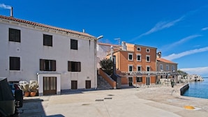 A coastal building with a staircase leading to a dock, adjacent to a body of water. - Antonella - Apartment Nikola (Mali Losinj)