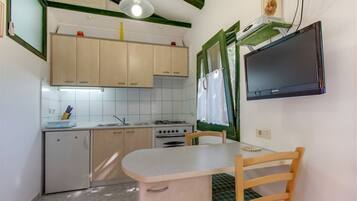 Studio | Privékitchenette | Een koelkast, een kookplaat, kookgerei, borden en bestek