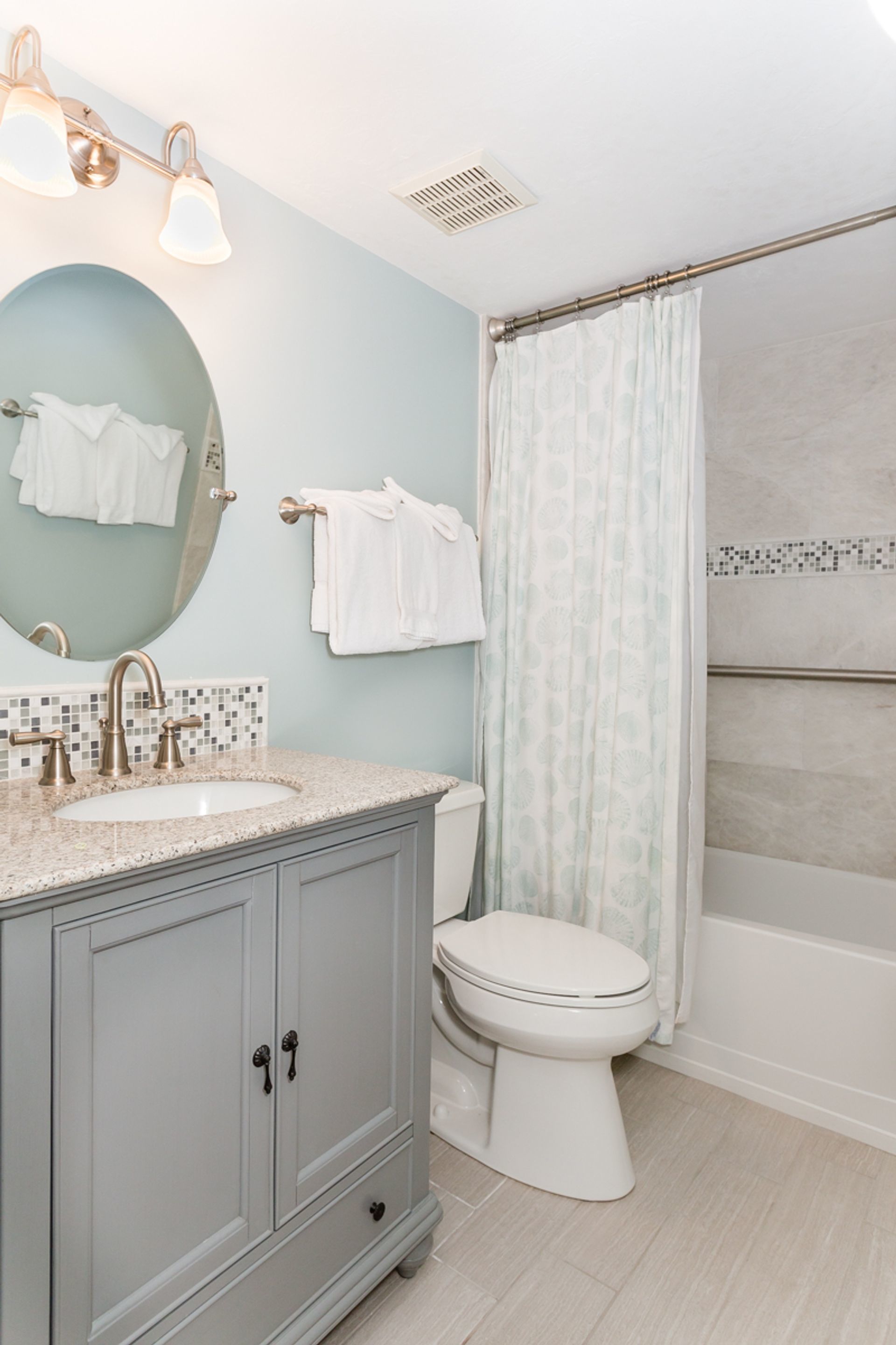 A bathroom with a sink, toilet, and shower curtain.