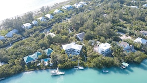 An aerial view of a coastal residential area with houses, a dock, and boats. - Sea Otter (Captiva)
