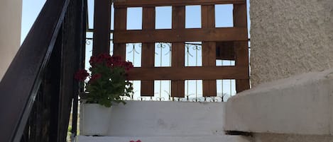 A staircase with white walls and a wooden fence in the background.