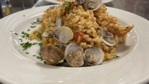 A plate of risotto with clams and herbs. - Gadames Hotel - Lunch on the Beach (Cervia)