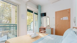A bedroom with a bed, a desk, a chair, a TV, and a door. - Gadames Hotel - Lunch on the Beach (Cervia)