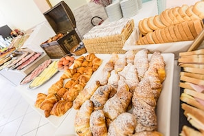 A variety of pastries and bread on display, including croissants, muffins, and bread rolls. - Gadames Hotel - Lunch on the Beach (Cervia)