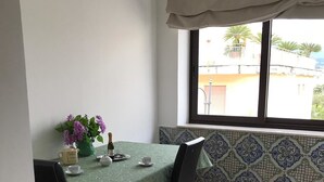 A dining area with a table set for two, a vase of flowers, and a bottle of wine. - Maison de Charme Iommella (Sant'Agnello)