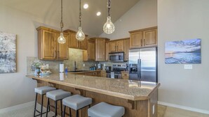 A kitchen with wooden cabinets, a granite countertop, stainless steel appliances, and pendant lighting. - Branson Lakefront Penthouse at The View- Emerald Pointe! (Hollister)
