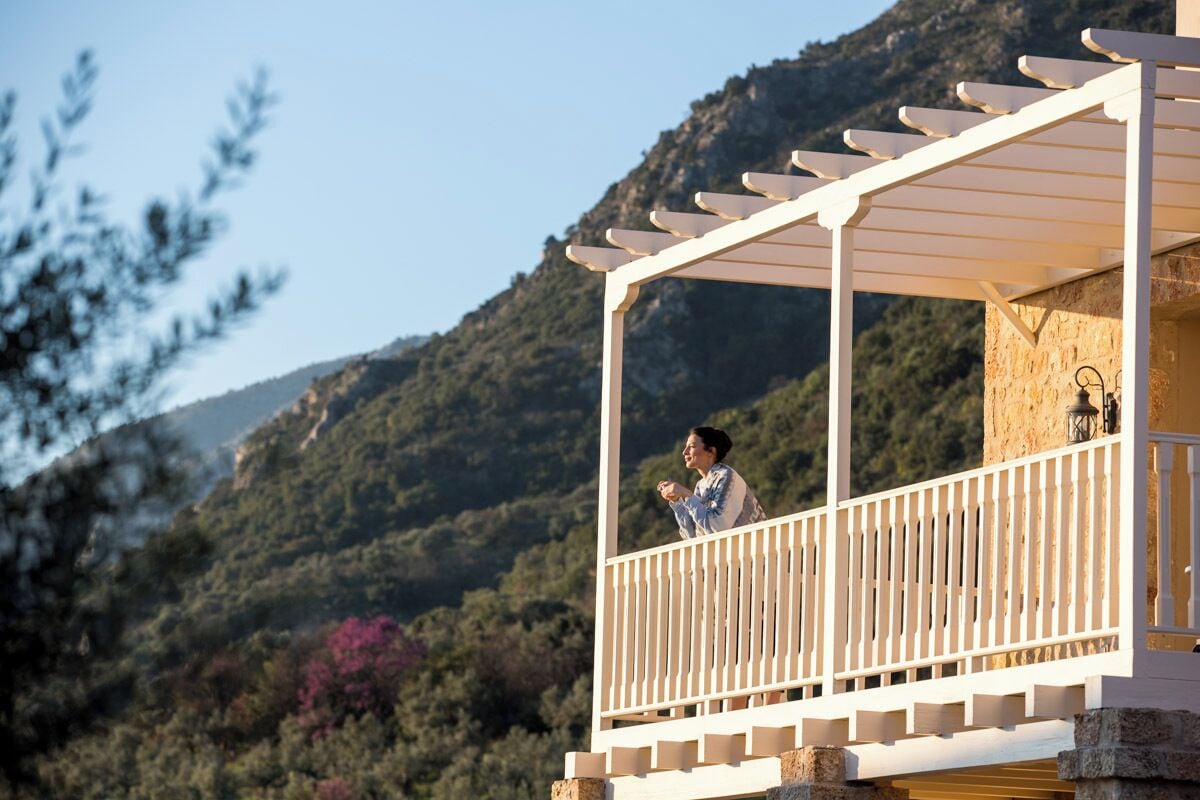 A balcony with a white railing overlooking a mountainous landscape.