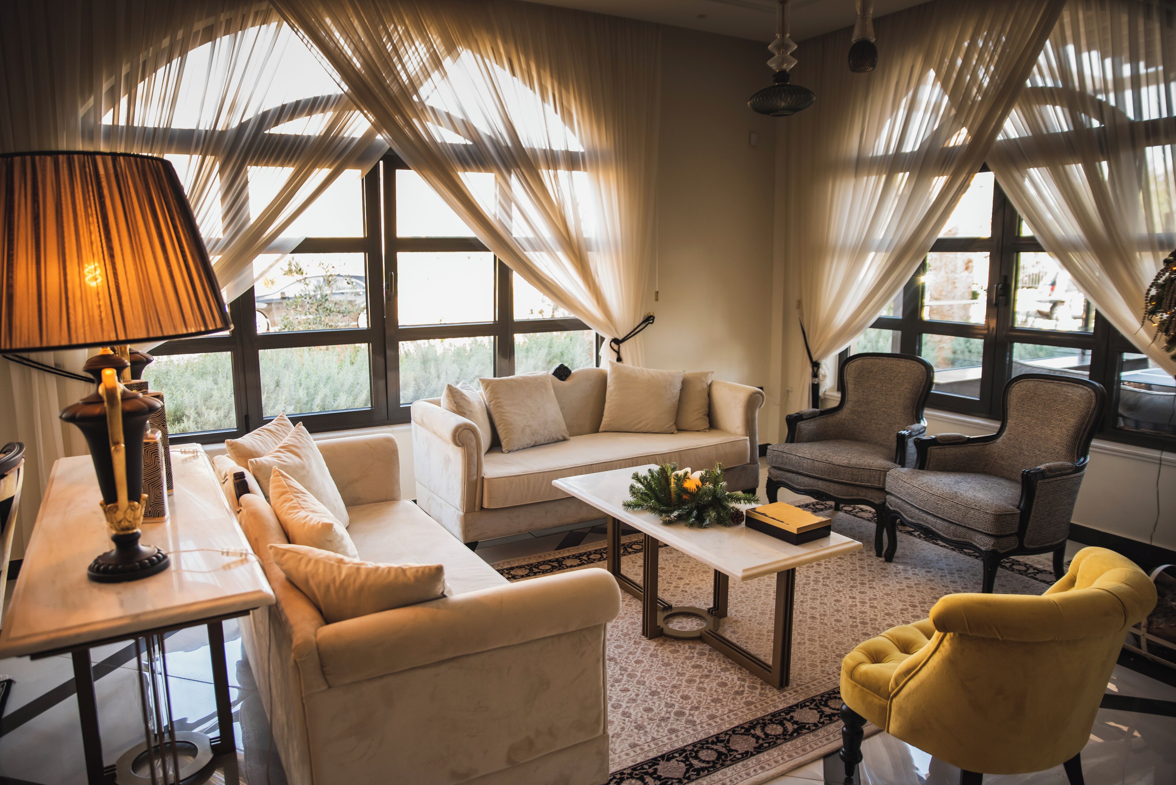 A living room with a sofa, armchairs, a coffee table, and a lamp.