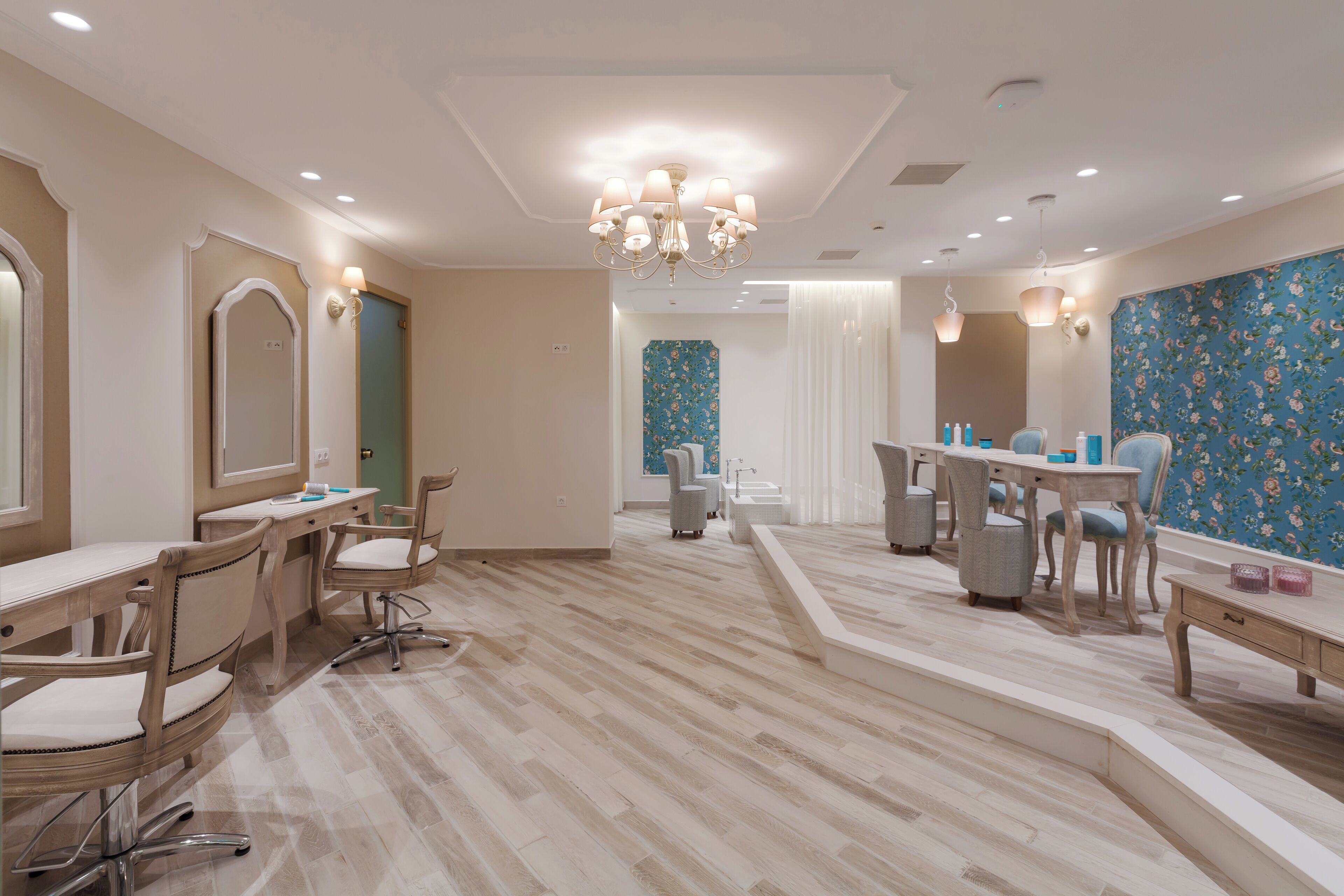 Un salón moderno con piso de madera, varias zonas de estar y un espejo grande.