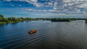 Ein Fluss mit einem Boot, umgeben von Grünflächen und Gebäuden.
