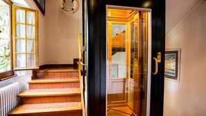 Una escalera de madera con peldaños y un vidrio que da a una habitación.
