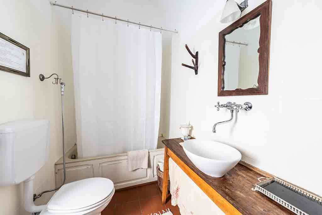A bathroom with a toilet, sink, and shower curtain.