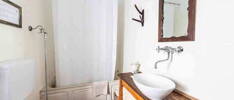 A bathroom with a toilet, sink, and shower curtain.