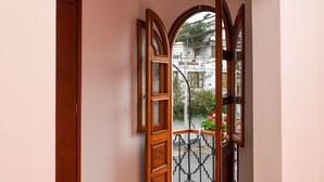 A hallway with wooden flooring and a view of a balcony with a railing. - Lima White House - Hostel (Lima)