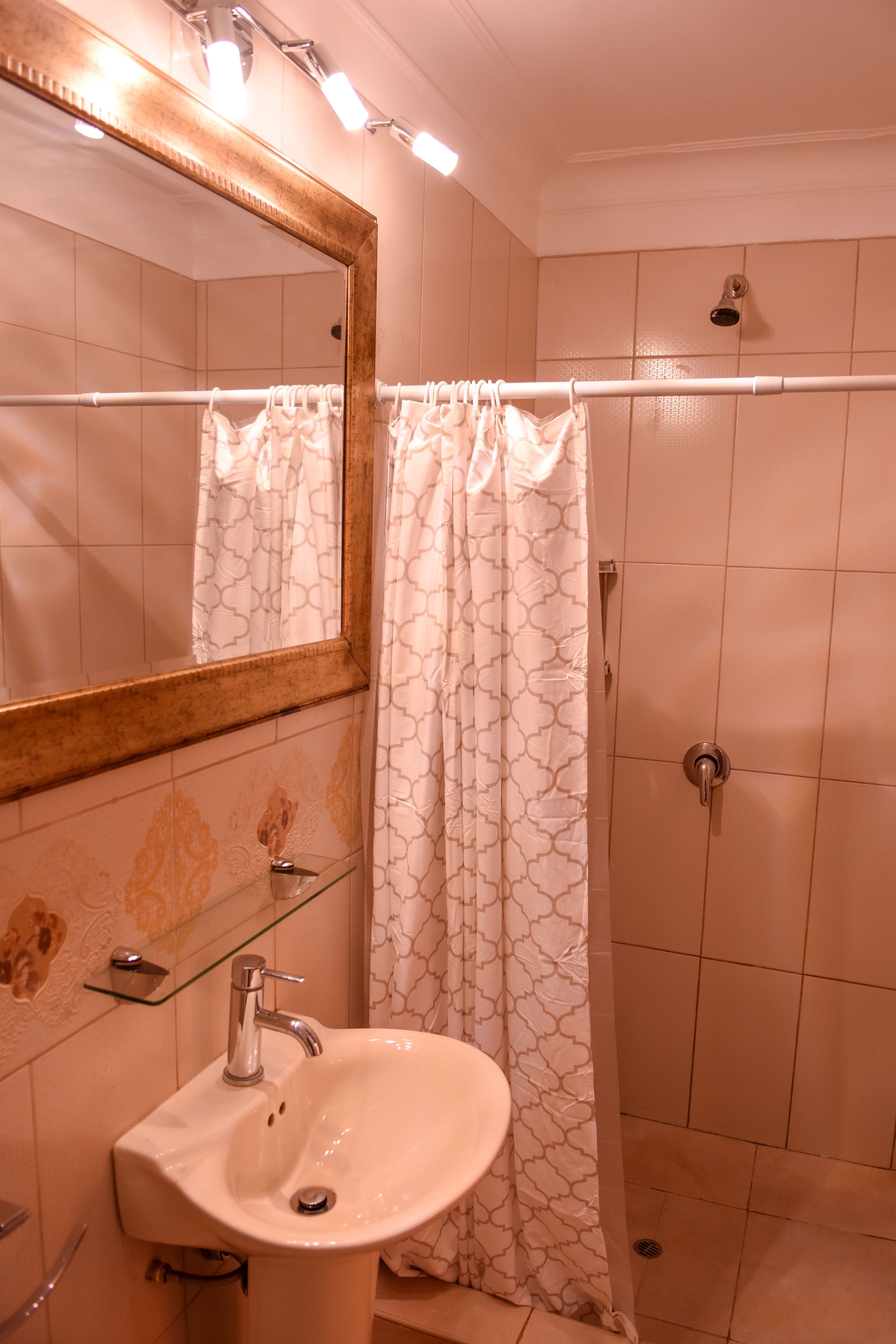 A bathroom with a white sink, a mirror, and a shower curtain.