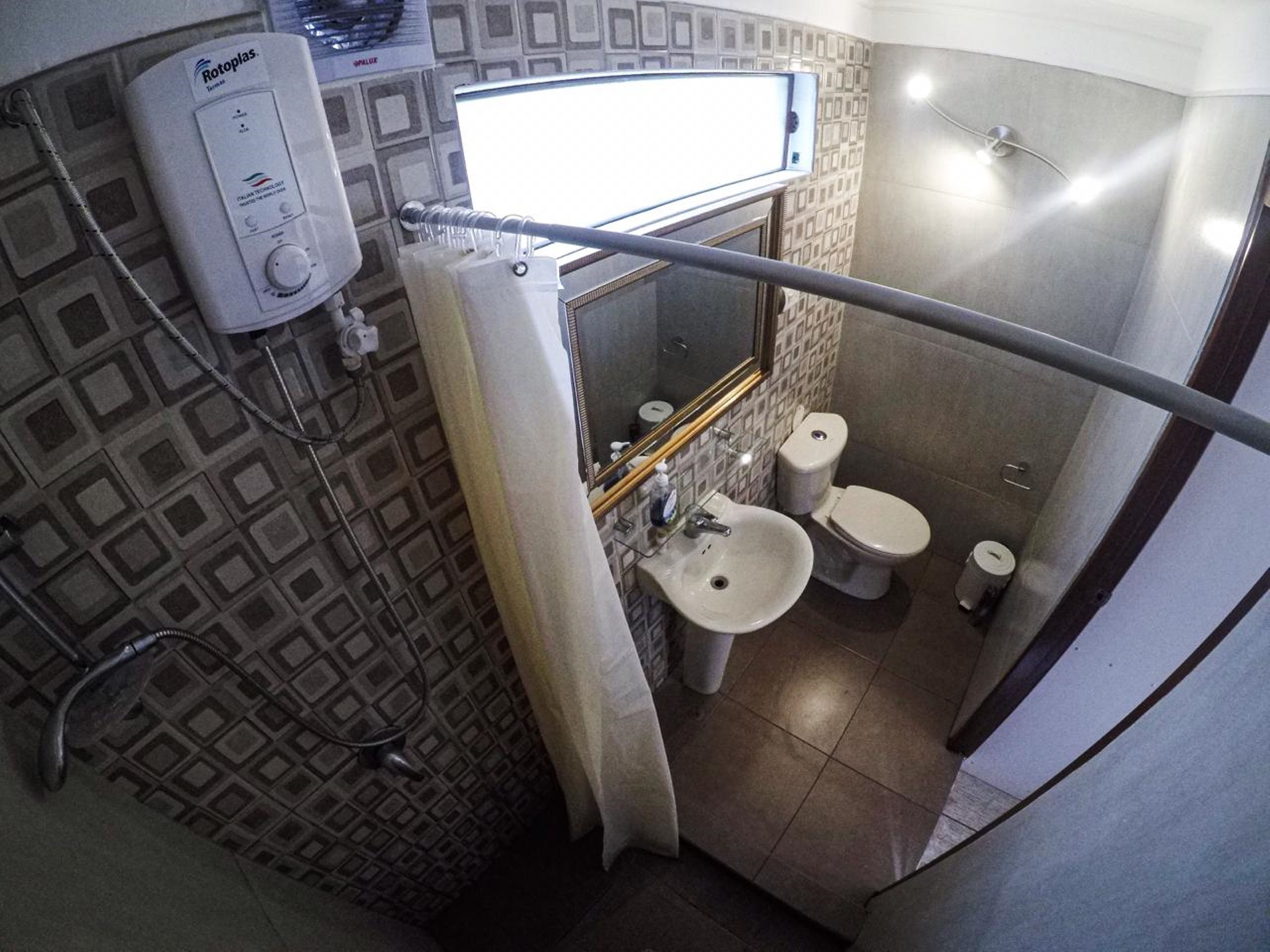 Une salle de bain avec des toilettes, un lavabo et une douche.