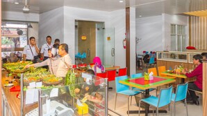 Een modern restaurant met verschillende zitmogelijkheden, zoals tafels en stoelen, en een balie voor het bestellen van eten.