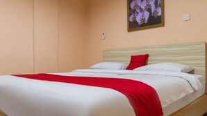 Un lit simple avec une tête de lit en bois, une literie blanche et un plaid rouge.