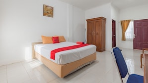 Een hotelkamer met een bed, een kledingkast en een stoel.
