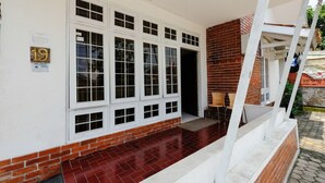 Un edificio con fachada de ladrillo rojo, ventanas con marcos blancos y un letrero con el número 19.