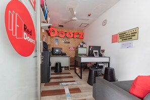 Een Red Doorz kantoor met een houten wand, een bureau, computer en een bank.