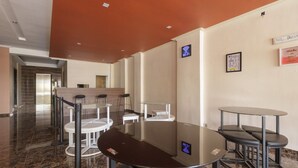 A modern conference room with glass tables and chairs, a Wi-Fi sign, and motivational wall art. - RedDoorz Plus @ Boulevard Panakkukang (Makassar)
