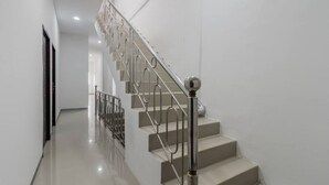 A modern staircase with metal railings and a glass balustrade, leading to an upper floor. - RedDoorz near Mall SKA Pekanbaru (Pekanbaru)