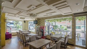 Ein Restaurant mit Innenbereich, einem Verkaufsautomaten und Blick auf die Straße.