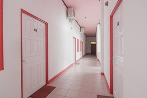 A corridor with white doors, each marked with a number. - KoolKost Syariah near Ayani Mega Mall Pontianak (Pontianak)