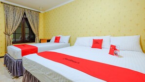 A hotel room with two beds, each with white bedding and red accents, including pillows and a red bed runner. - RedDoorz @ Jalan Setiabudi Semarang (Semarang)