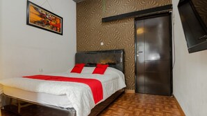 A bedroom with a bed, a wardrobe, and a patterned wall. - RedDoorz Syariah @ Taman Bendungan Asahan (Jakarta)