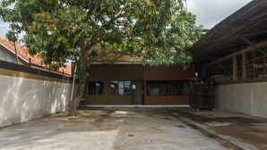 A courtyard with a building that has a brown facade and large windows. - RedDoorz near Cikampek Mall Karawang (Karawang)