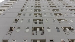 A high-rise building with multiple balconies and air conditioning units. - RedDoorz Apartment @ Dramaga Tower (Ciampia)