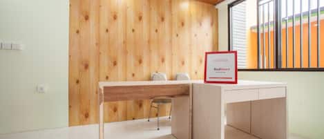 Un mostrador de recepción con un panel de pared de madera, un letrero que indica un socio, y una ventana con persianas.