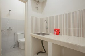 Une salle de bain avec des toilettes, un lavabo et une douche.
