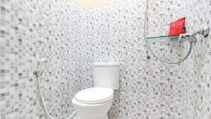 A bathroom with a toilet, a shower, and a glass shelf with a red item. - RedDoorz near Balekambang City Park (Surakarta)