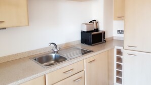 Apartamento conforto, 1 cama de casal, vista para a cidade | Cozinha privada | Geladeira grande, micro-ondas (mediante solicitação), fogão, cooktop