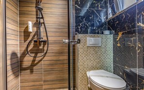 A bathroom with a shower, toilet, and a tiled wall. - Villa San Rocco Bed&Breakfast (Medulin)