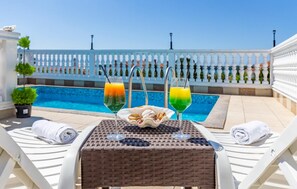 A poolside table with two drinks, a bowl of snacks, and towels. - Villa San Rocco Bed&Breakfast (Medulin)