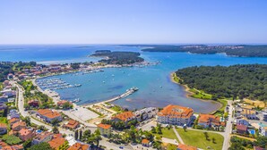 An aerial view of a coastal town with a marina, residential buildings, and a clear blue sky. - Villa San Rocco Bed&Breakfast (Medulin)