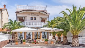 Villa Sah Rocco with a terrace, outdoor seating, and palm trees. - Villa San Rocco Bed&Breakfast (Medulin)
