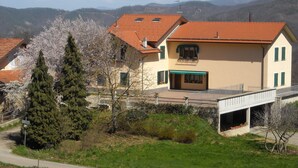 A two-story house with a red-tiled roof, a balcony, and a garage. - Azienda Agrituristica Lavagè (Rossiglione)