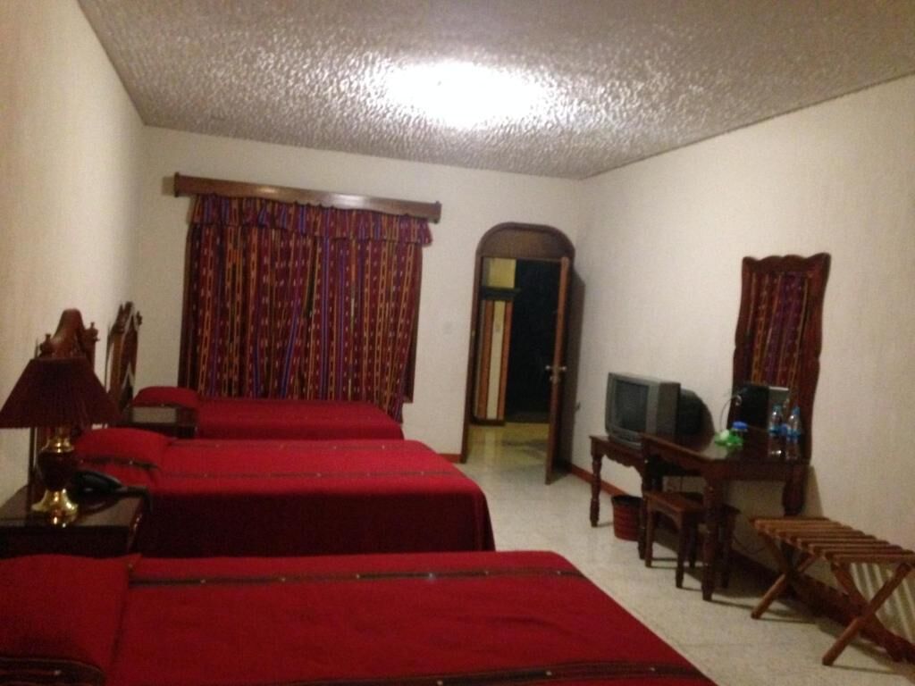 Une chambre d’hôtel avec deux lits, une télévision, un bureau et une chaise.