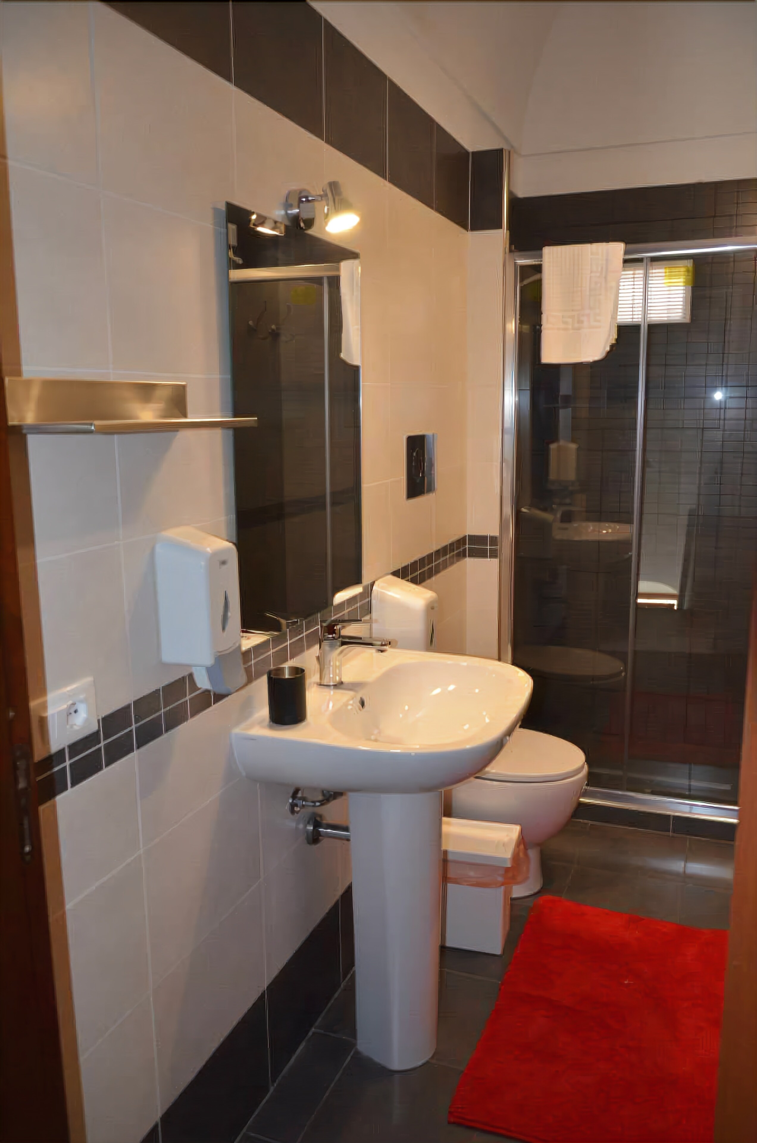 A modern bathroom with a sink, toilet, and shower.