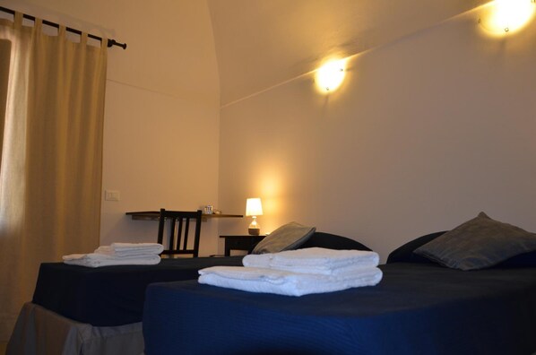 A hotel room with two beds, a desk, a lamp, and a curtain. - Ro.Ri Rooms (San Vito Lo Capo)