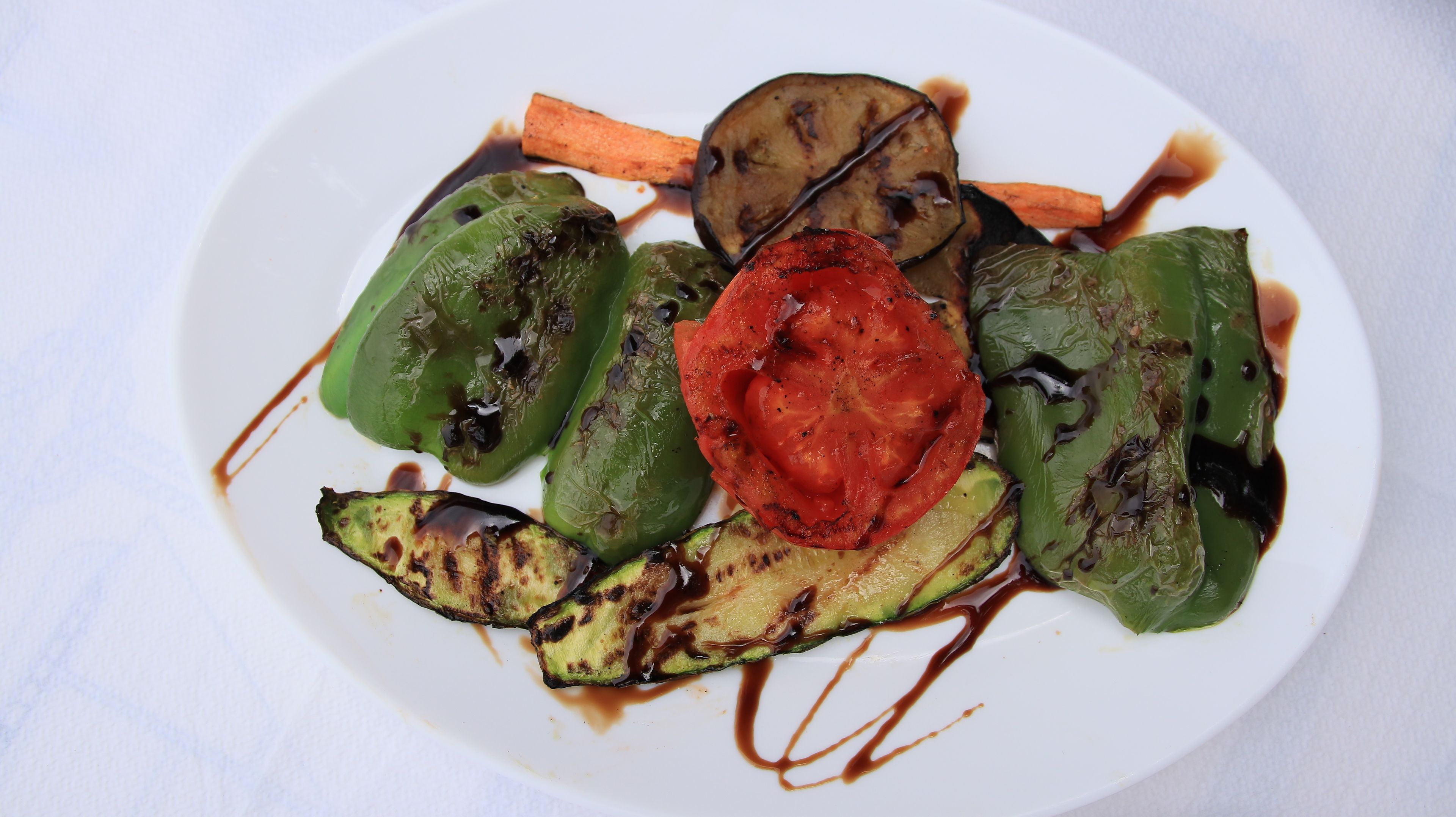 Un plat de verdures a la planxa amb un raig de salsa.