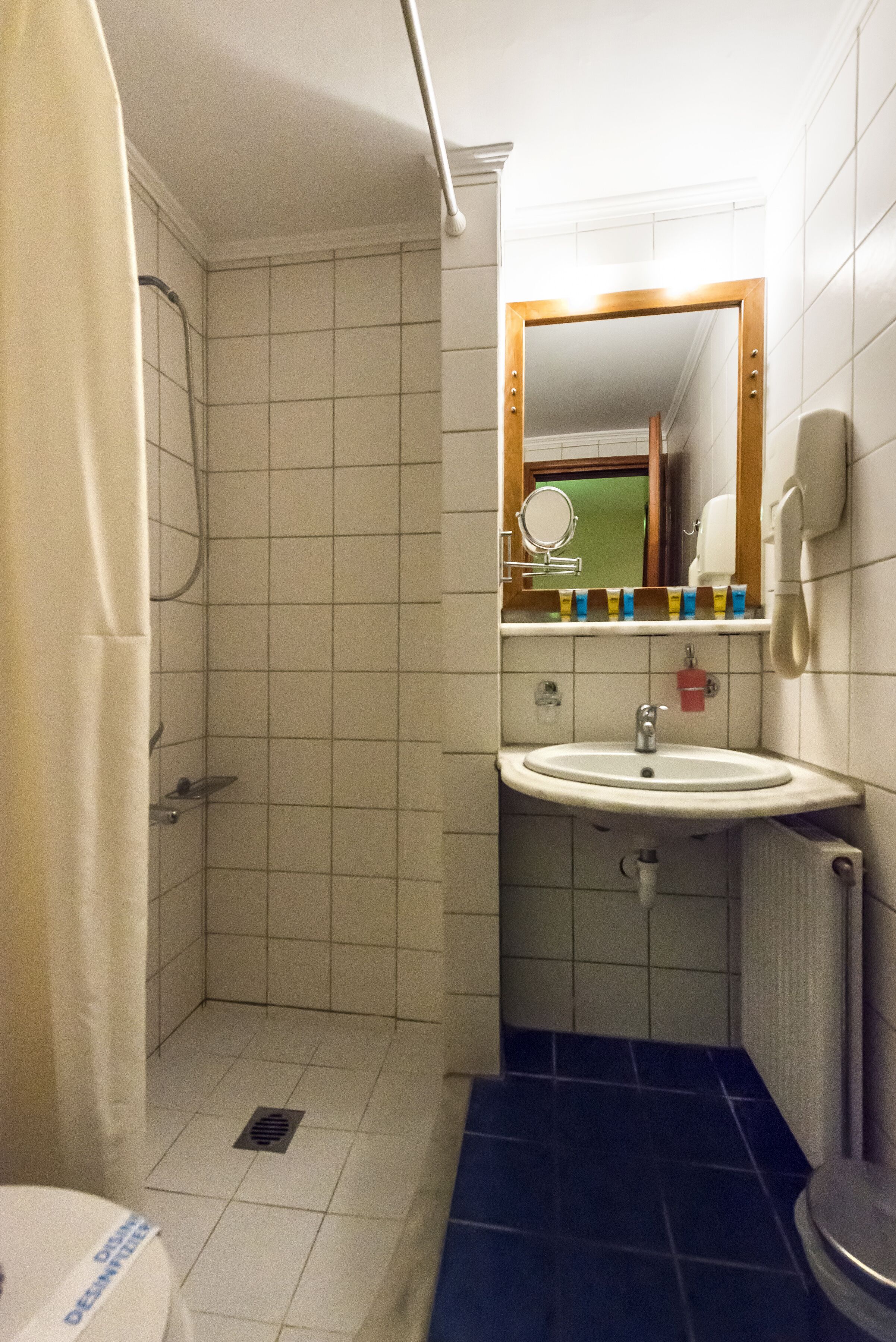 A small bathroom with a shower, sink, and toilet.