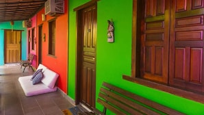 A corridor with colorful walls and wooden doors, a bench, and a sofa.