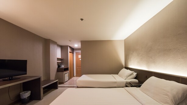 Une chambre d’hôtel comprenant un lit, une télévision, une petite kitchenette et une salle de bain.